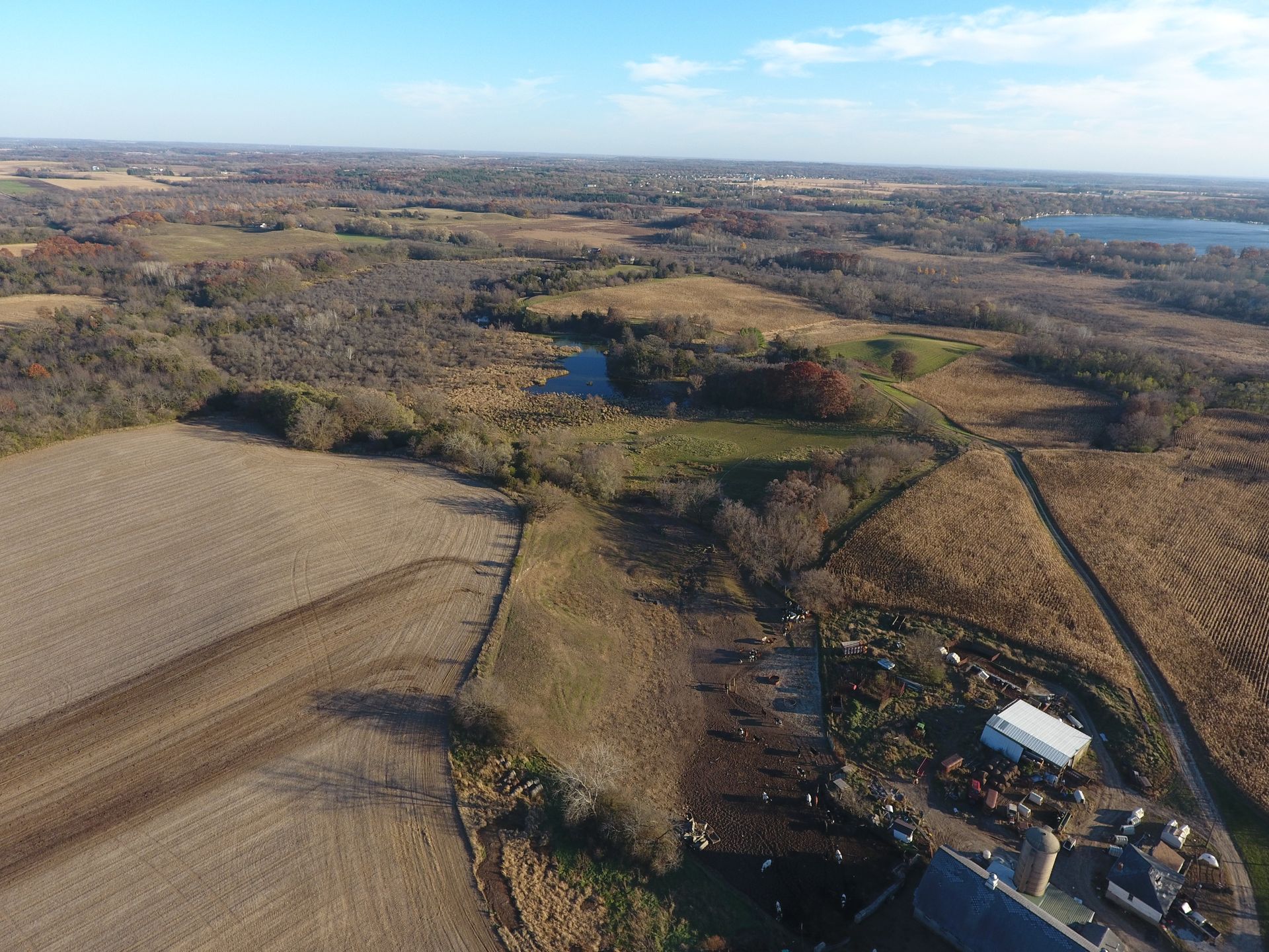 An aerial view of a farm surrounded by fields and trees.