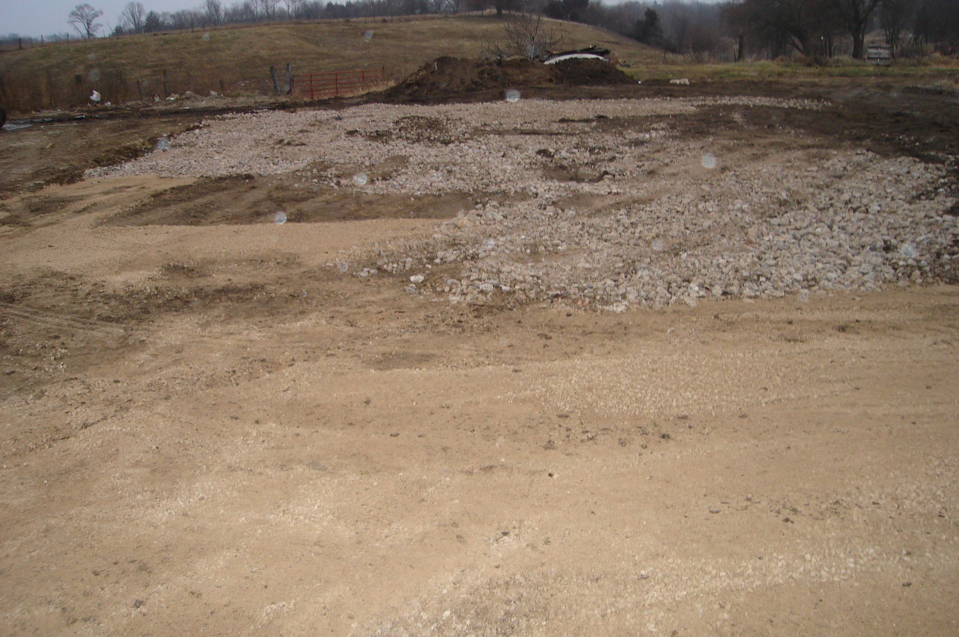There is a lot of dirt and rocks in the middle of the field.