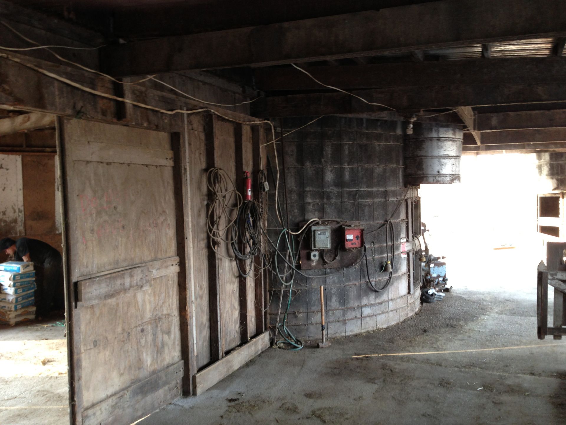 An empty barn with a silo in the middle of it