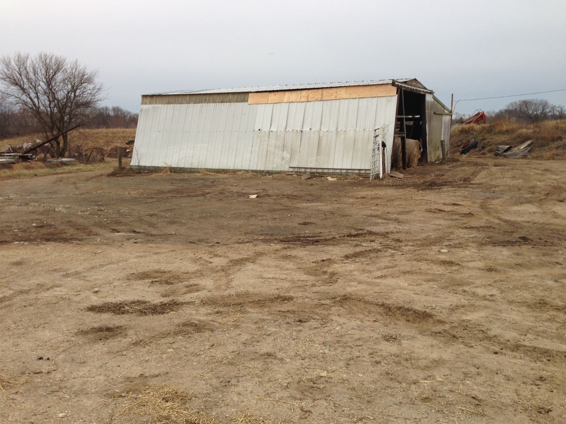 A white building in the middle of a dirt field