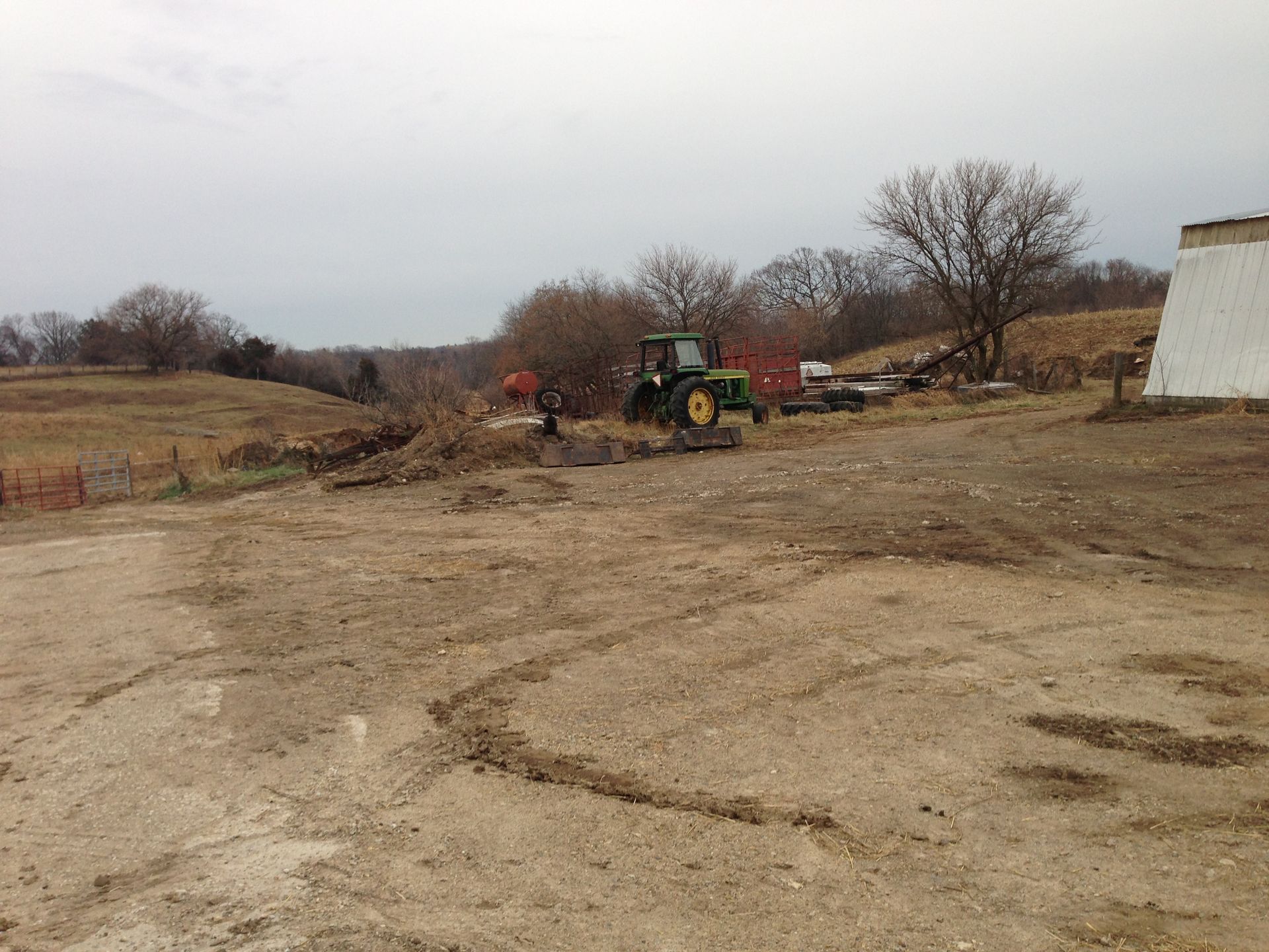A john deere tractor is parked in a dirt field