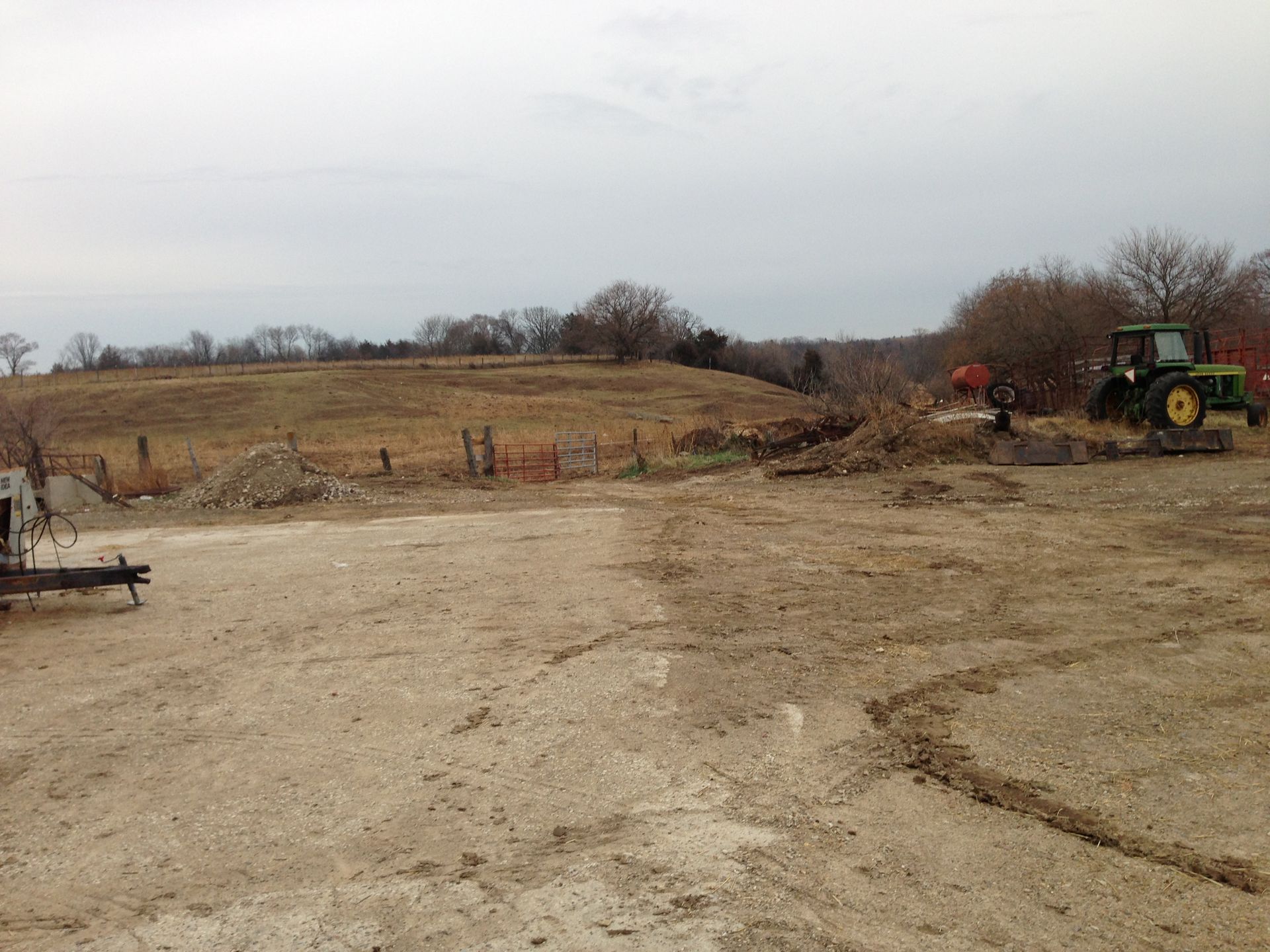 A tractor is parked in the middle of a dirt field