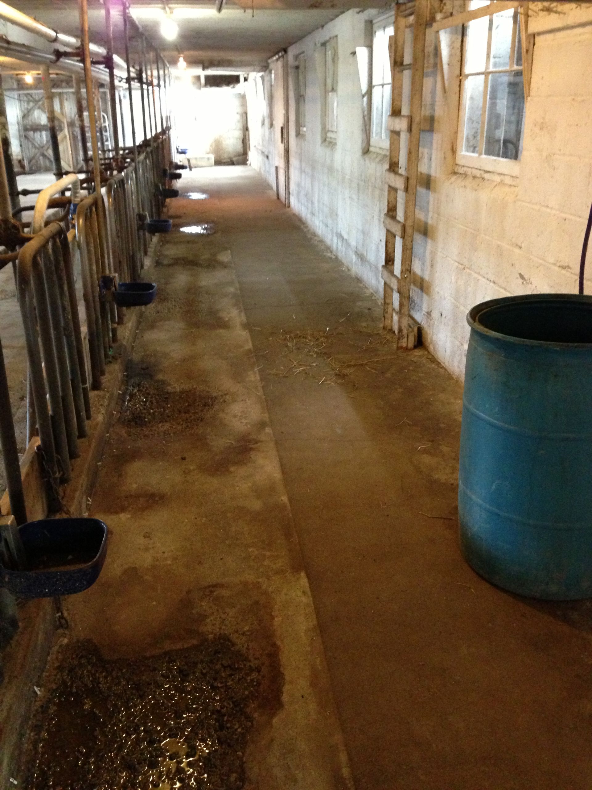 A long hallway with a blue barrel in the middle