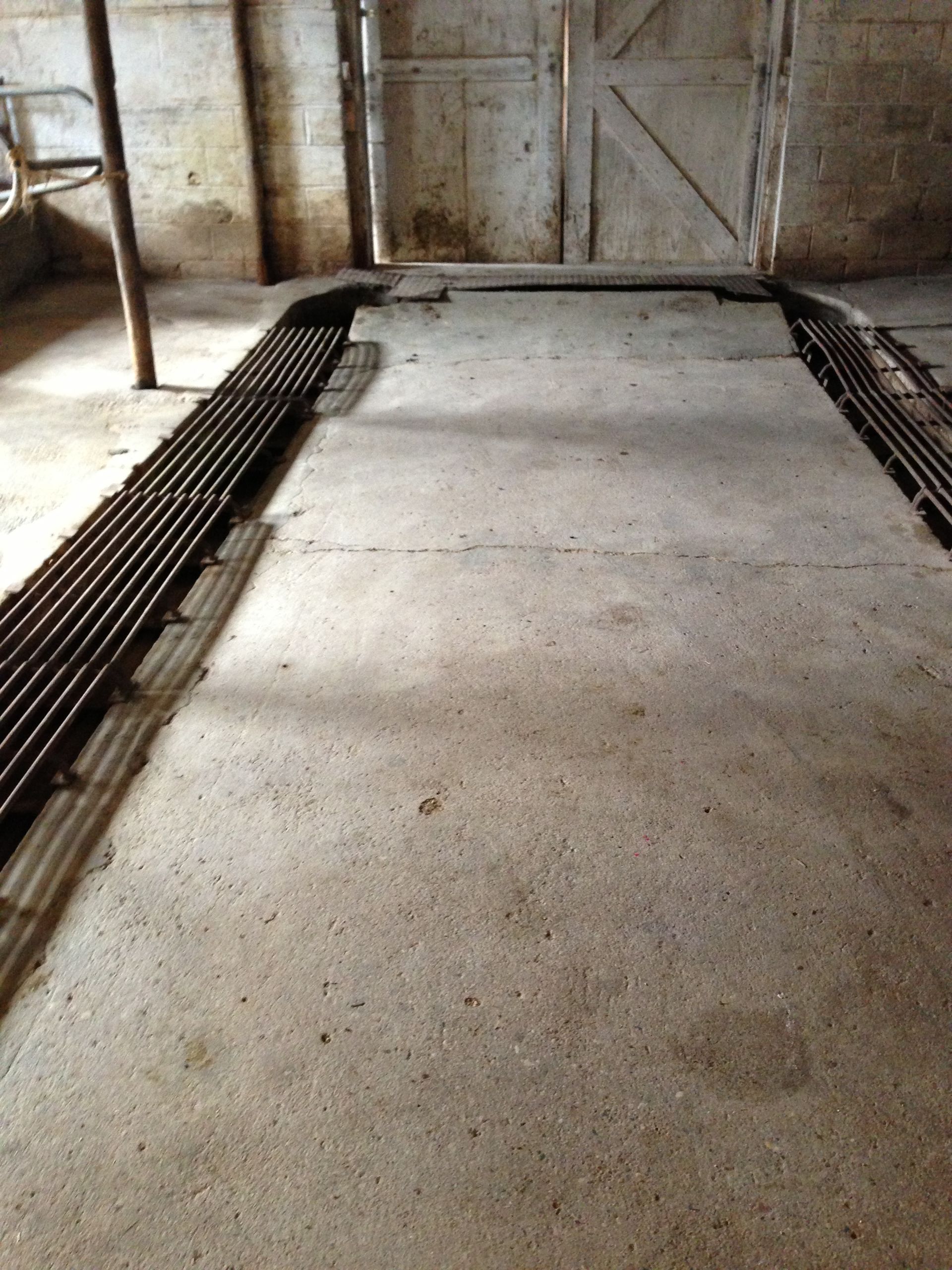 A room with a concrete floor and a metal railing