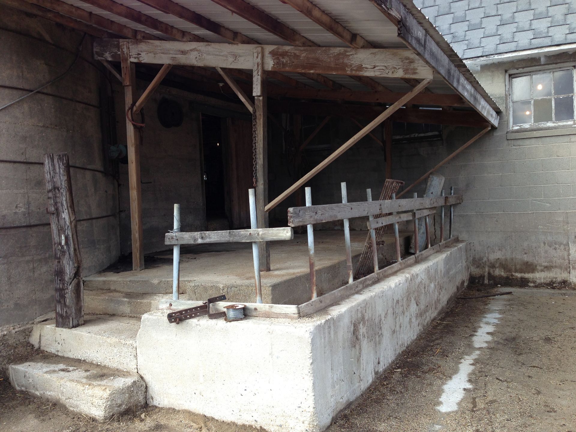 A porch with a wooden fence and stairs leading up to it