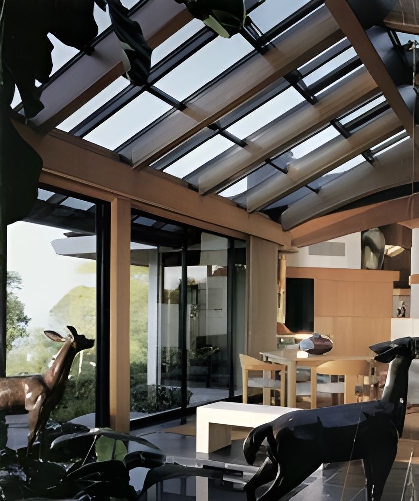 A living room with a table and chairs and a glass ceiling