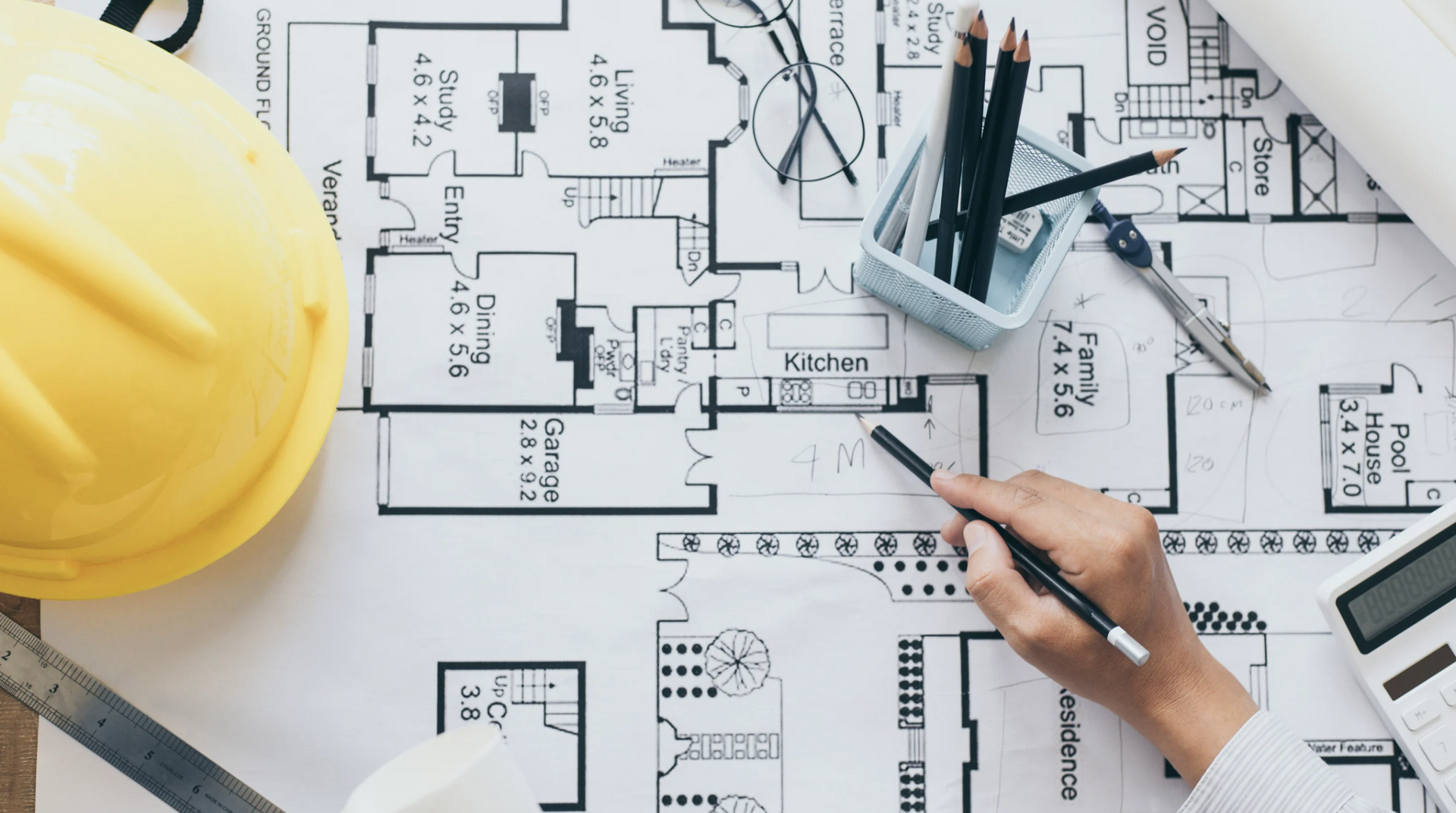 A person is drawing a floor plan of a house.