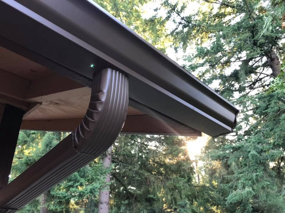 A close up of a gutter with trees in the background