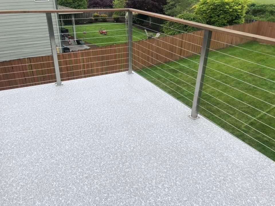 A balcony with a stainless steel railing and a wooden railing.