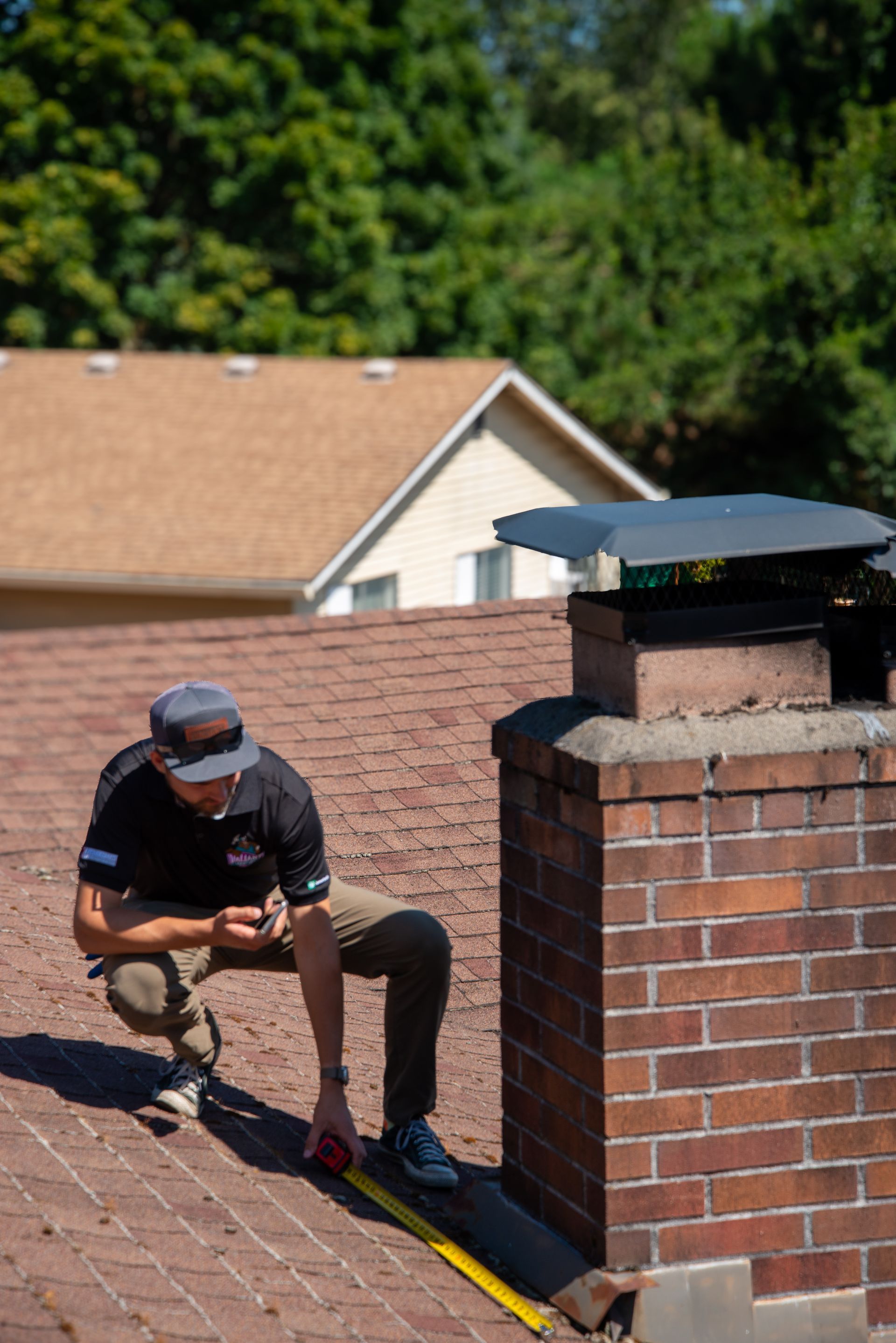 A close up of a roof with shingles and a chimney.