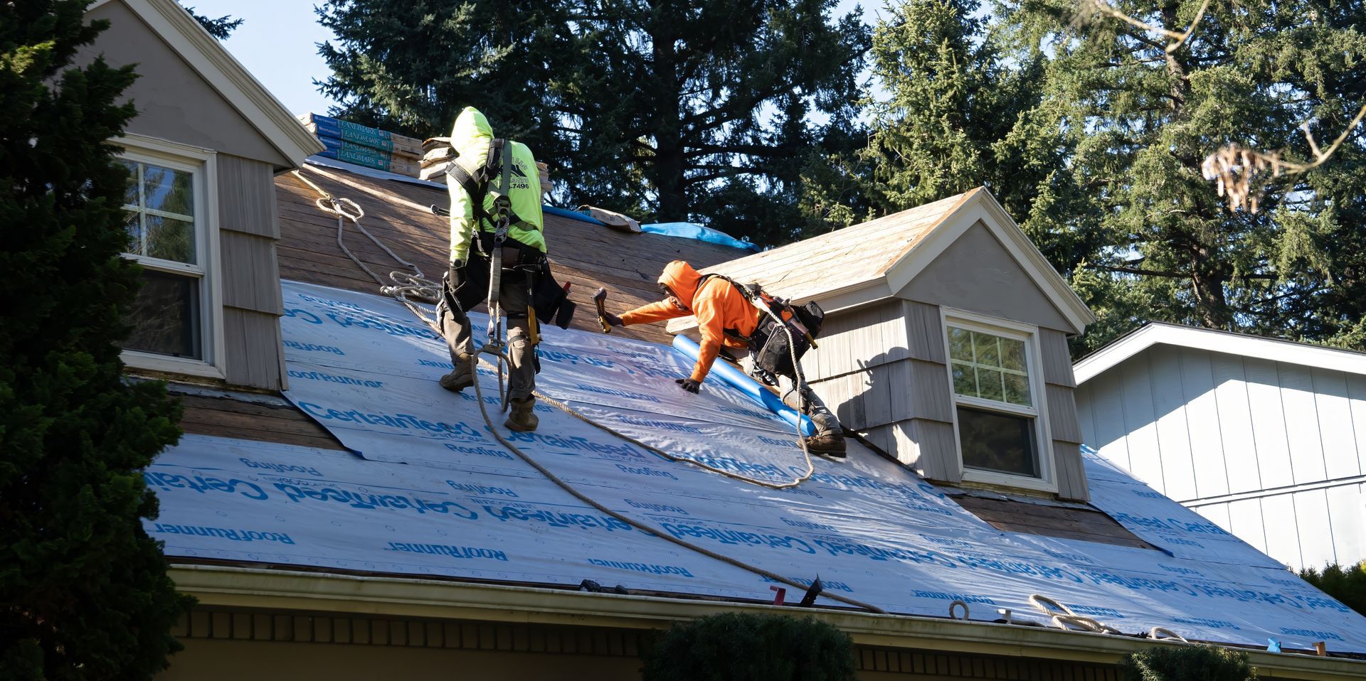 A group of men are working on the roof of a house.