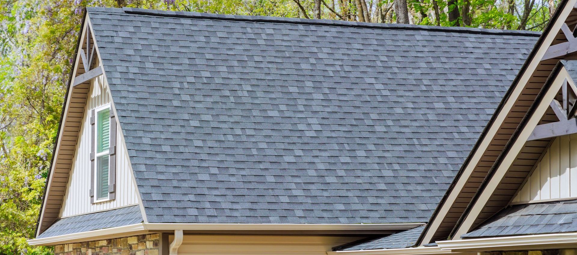 A house with a gray roof and trees in the background.