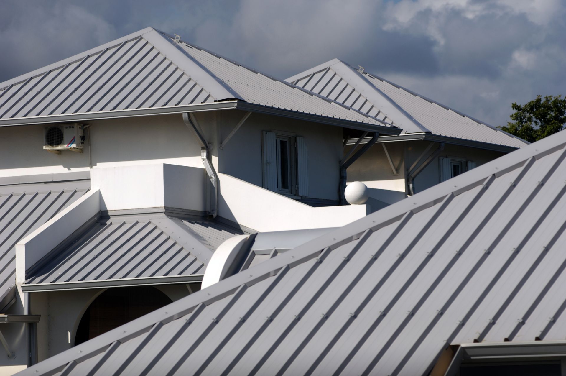 A white house with a silver metal roof