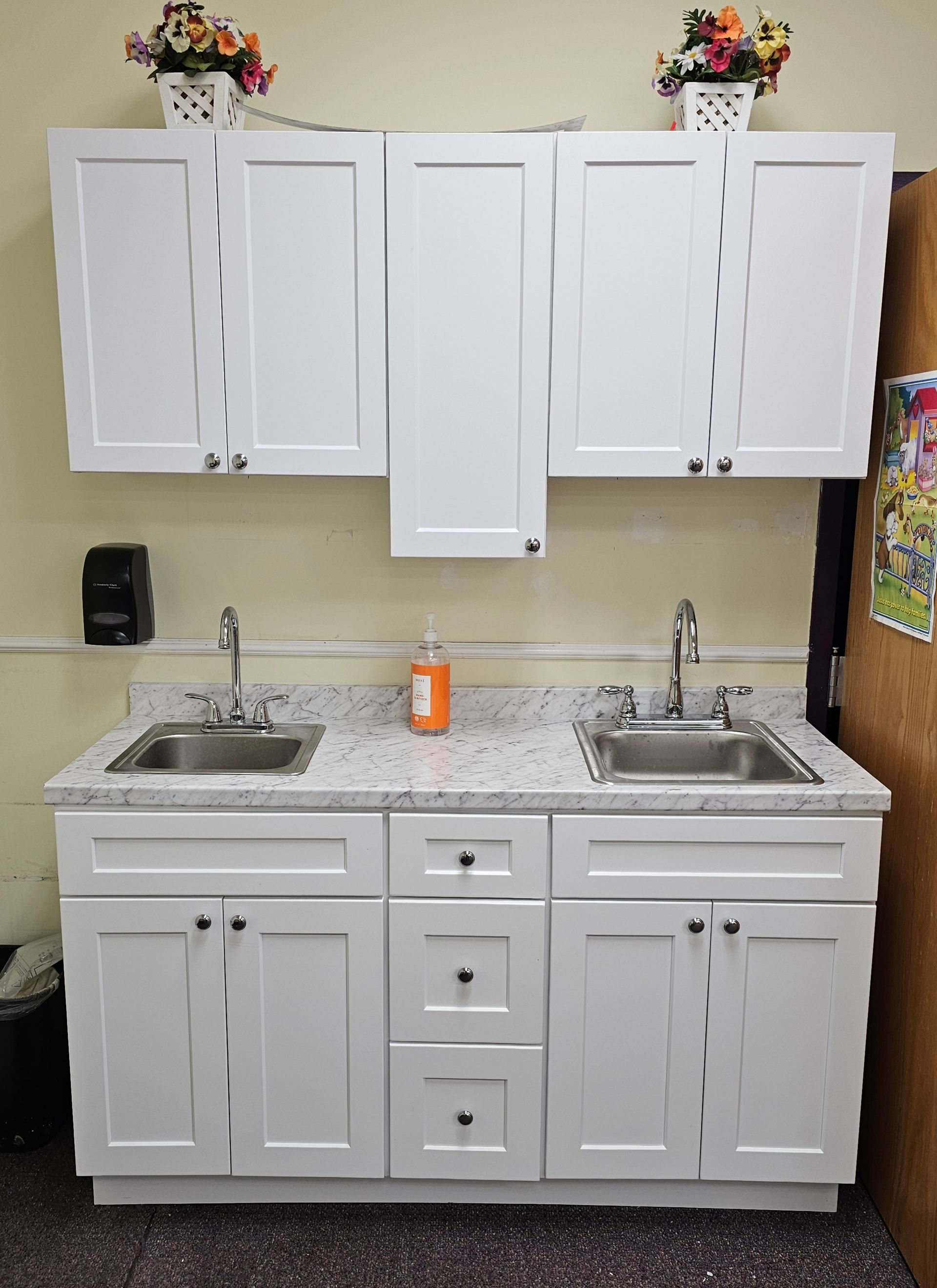 White cabinets with two sinks, granite countertop, and upper cabinets with flowers.