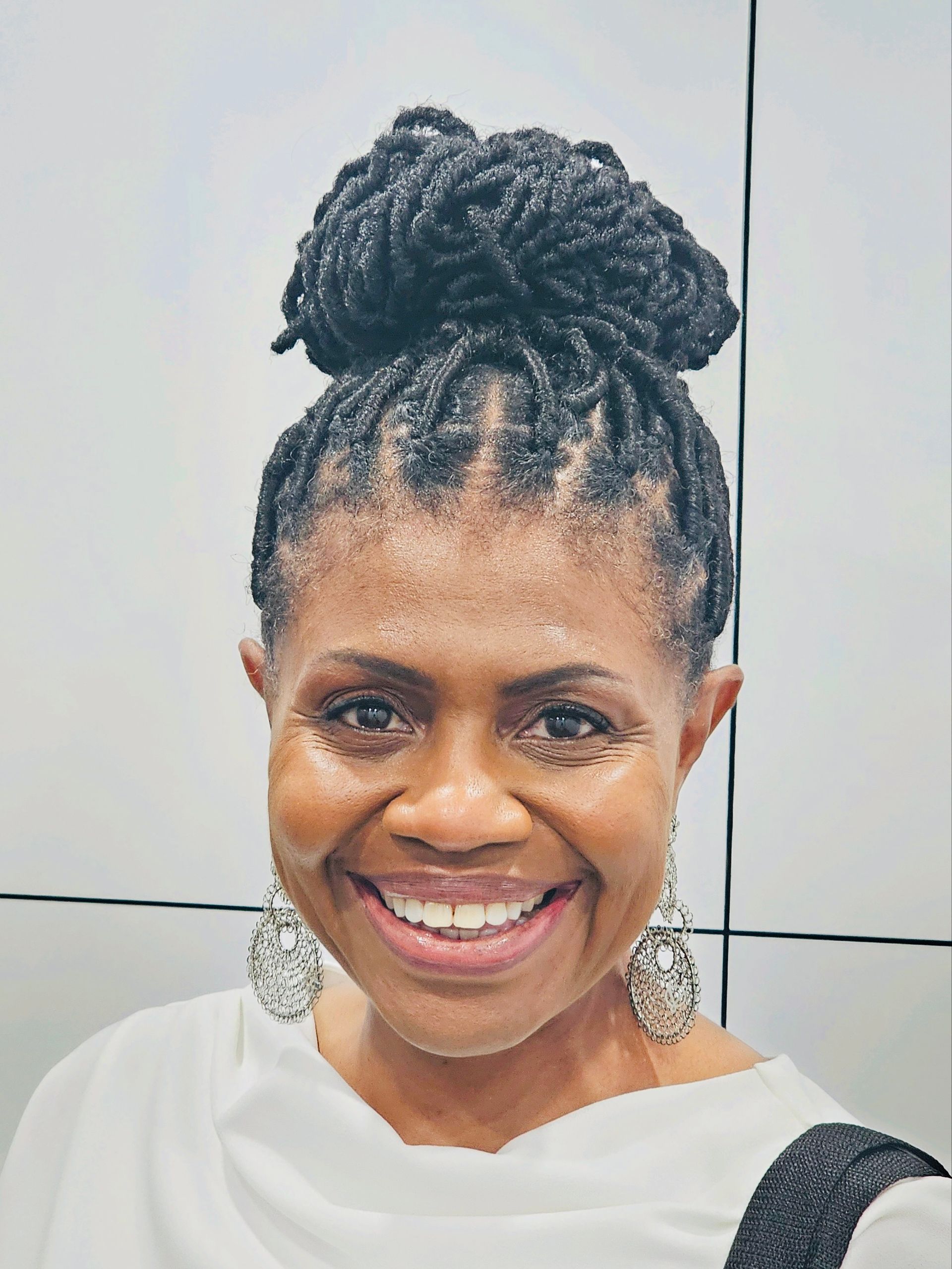 A woman in a red sweater is smiling for the camera.