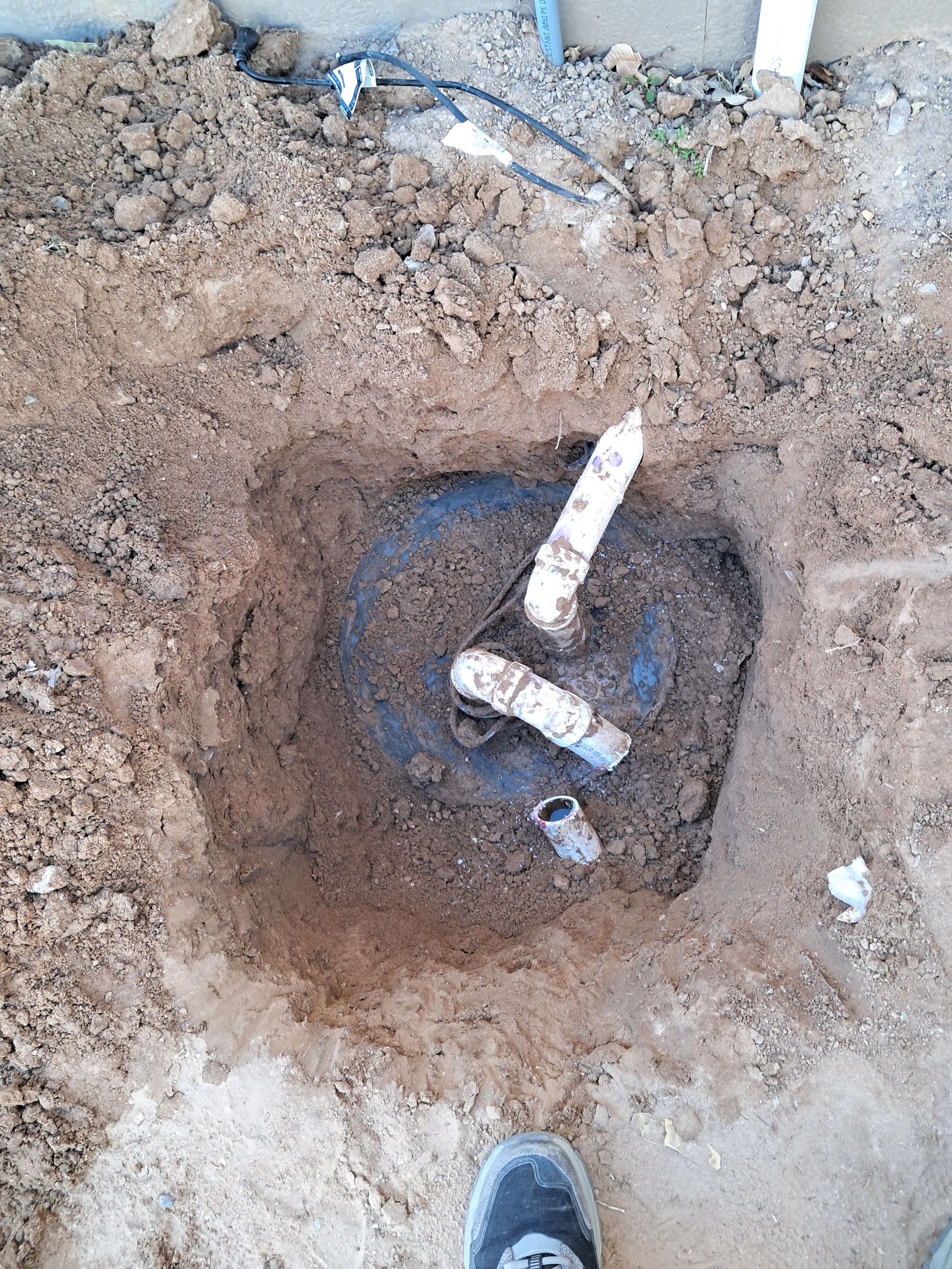 Pipes and valves connected to a wall. Several silver pipes with red valves and clamps.