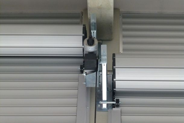 Una porta da garage con pannelli effetto legno installata in un telaio metallico all'interno di un magazzino.