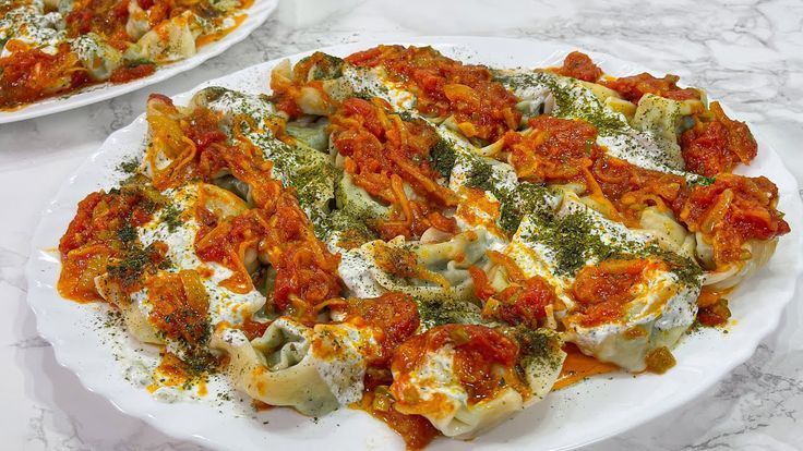 Close-up of Temorian ashak dumplings topped with yogurt and sprinkled with red and green spices Close-up of Temorian ashak dumplings topped with yogurt and sprinkled with red and green spices