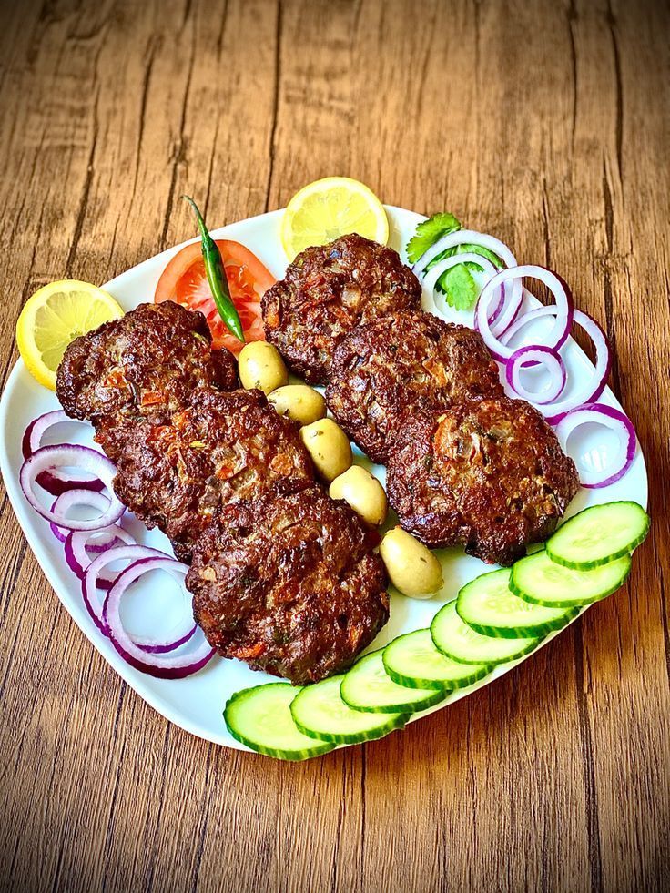 A plate of food with meat and vegetables on a wooden table.