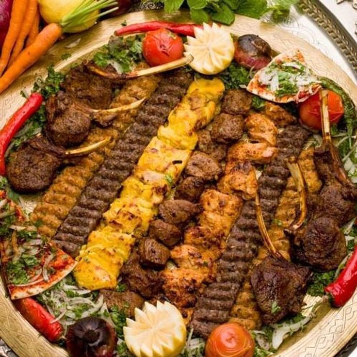 A plate of assorted kabobs at Temorian Restaurant , featuring grilled lamb , chicken, and miced meat skewers , served with rice and fresh herbs A plate of assorted kabobs at Temorian Restaurant , featuring grilled lamb , chicken, and miced meat skewers , served with rice and fresh herbs