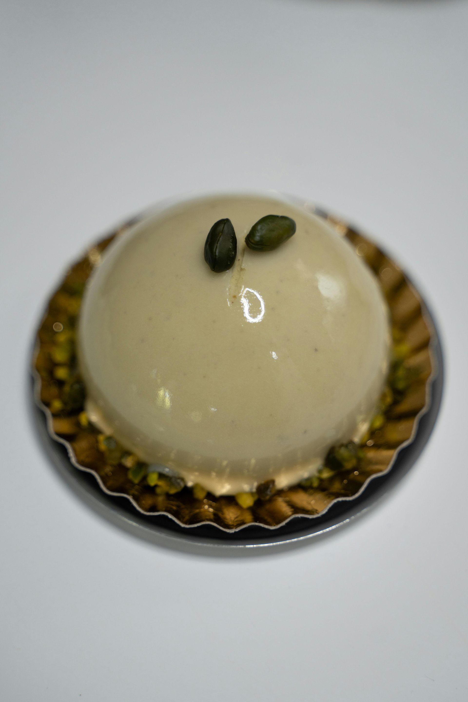 A white cake with pistachios on top of it