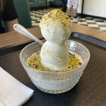 plate of sheeryakh( afghan ice cream) at the temorian restaurant A traditional afghan dessert called sheeryakh served in a bowl at temorian restaurant , topped with crushed pistachios and drizzled with rosewater syrup