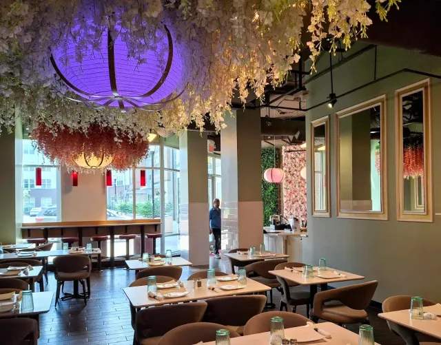 A restaurant with tables and chairs and a surfboard in the background.