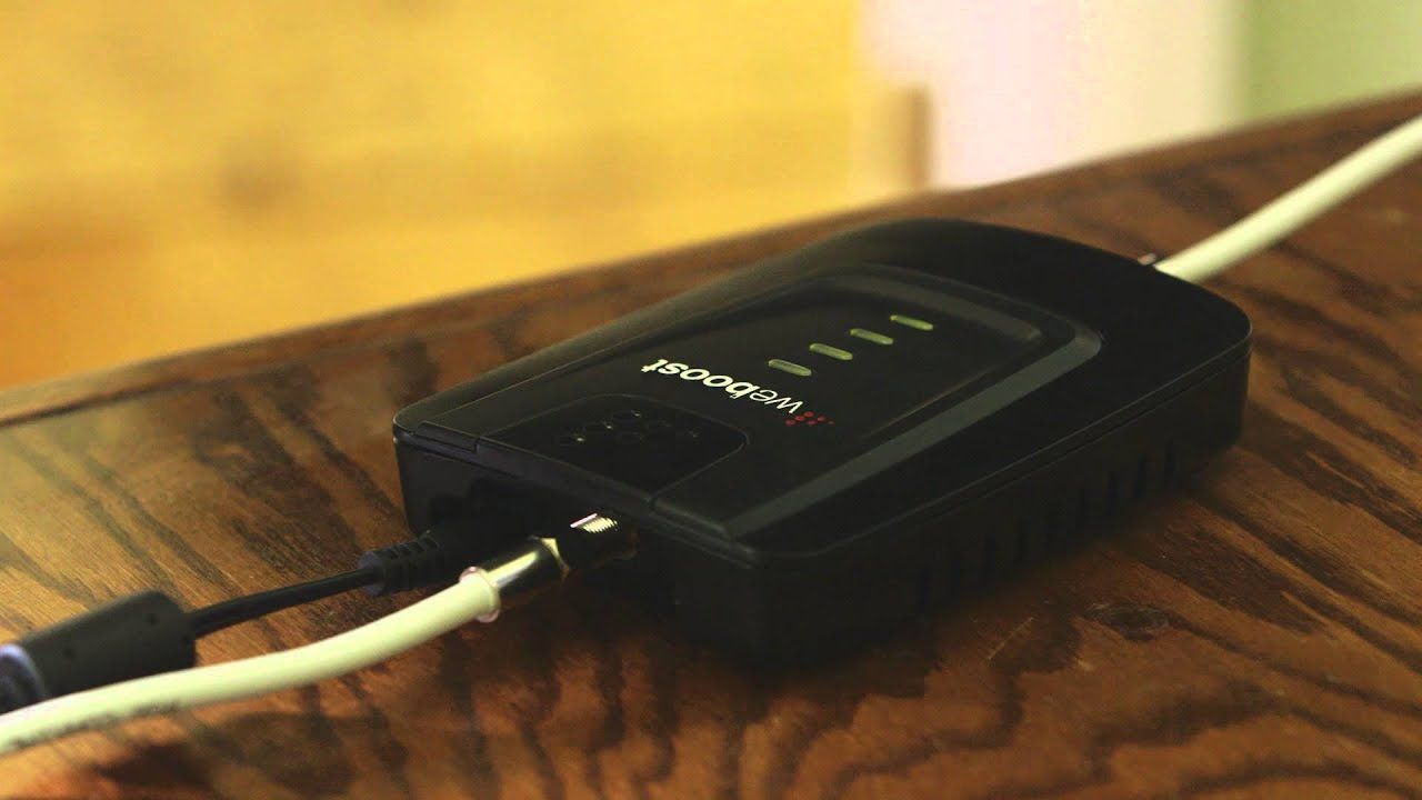 A black device is sitting on a wooden table
