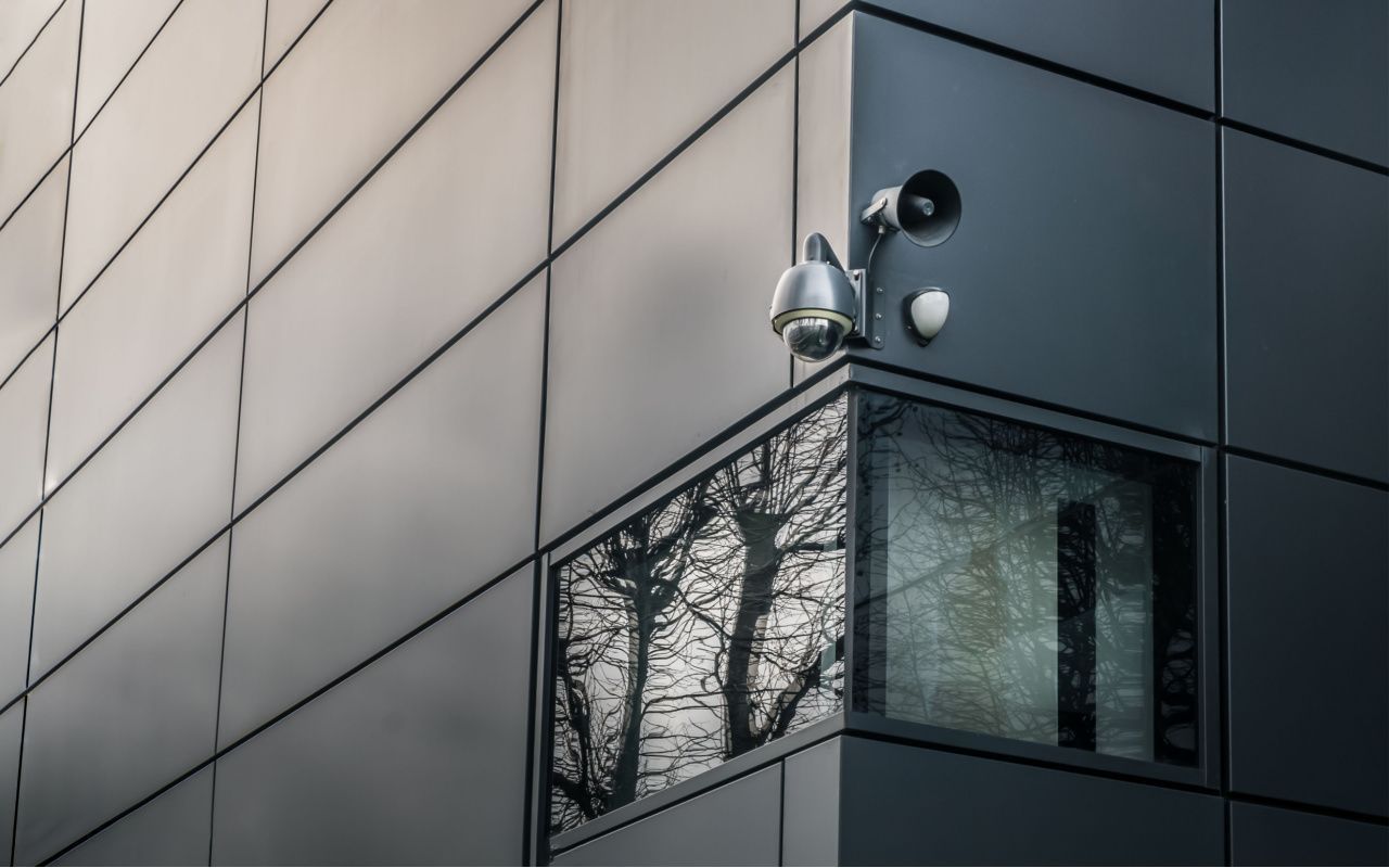 A security camera is mounted on the side of a building.