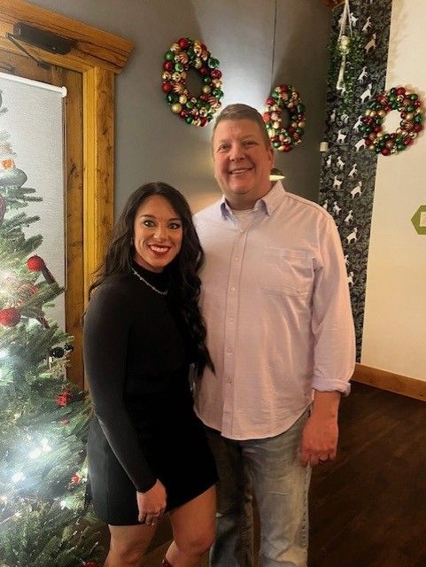 Family of four smiling, posing together on a couch indoors. Family of four smiling, posing together on a couch indoors.
