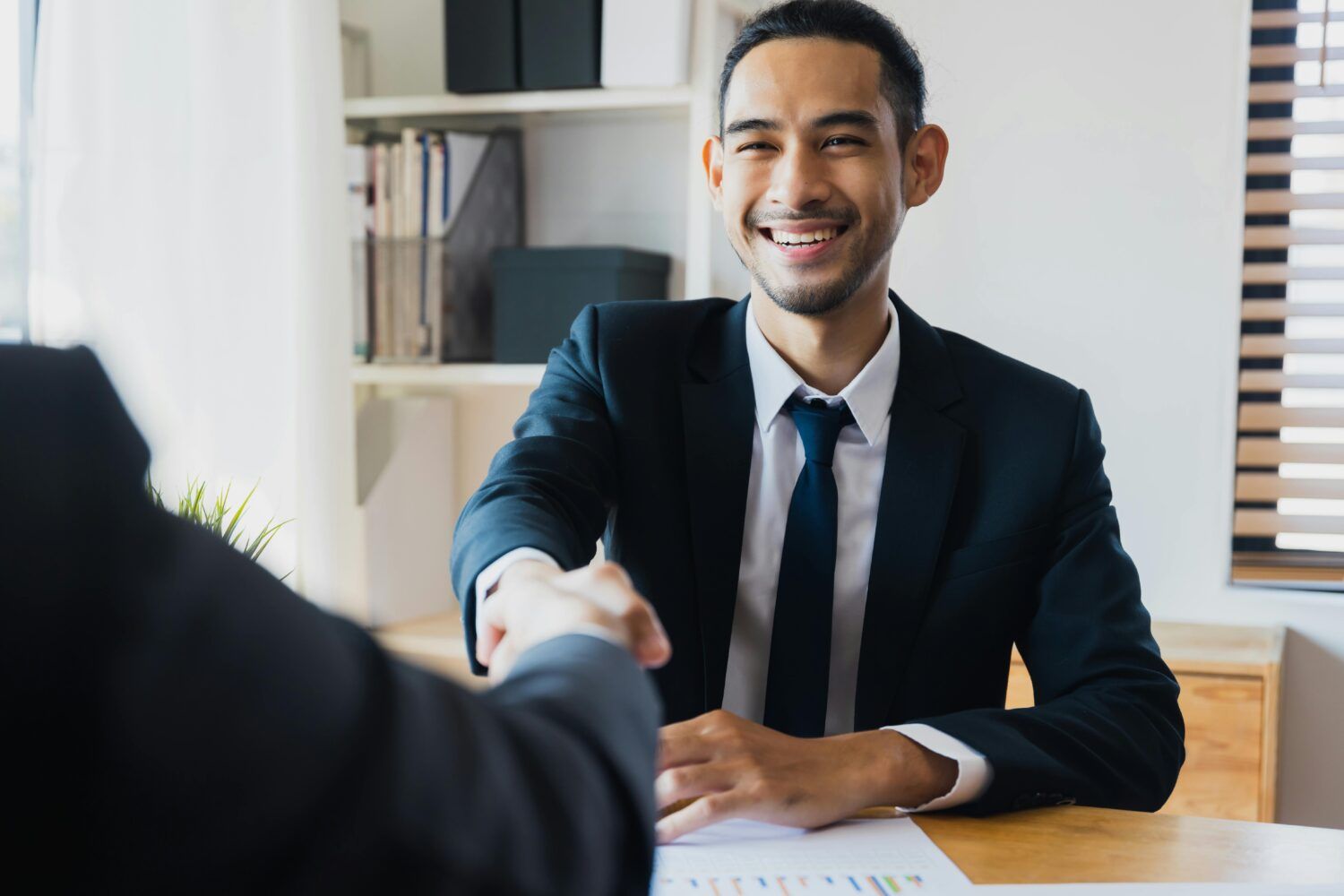 Businessman smiling during a handshake in an office setting