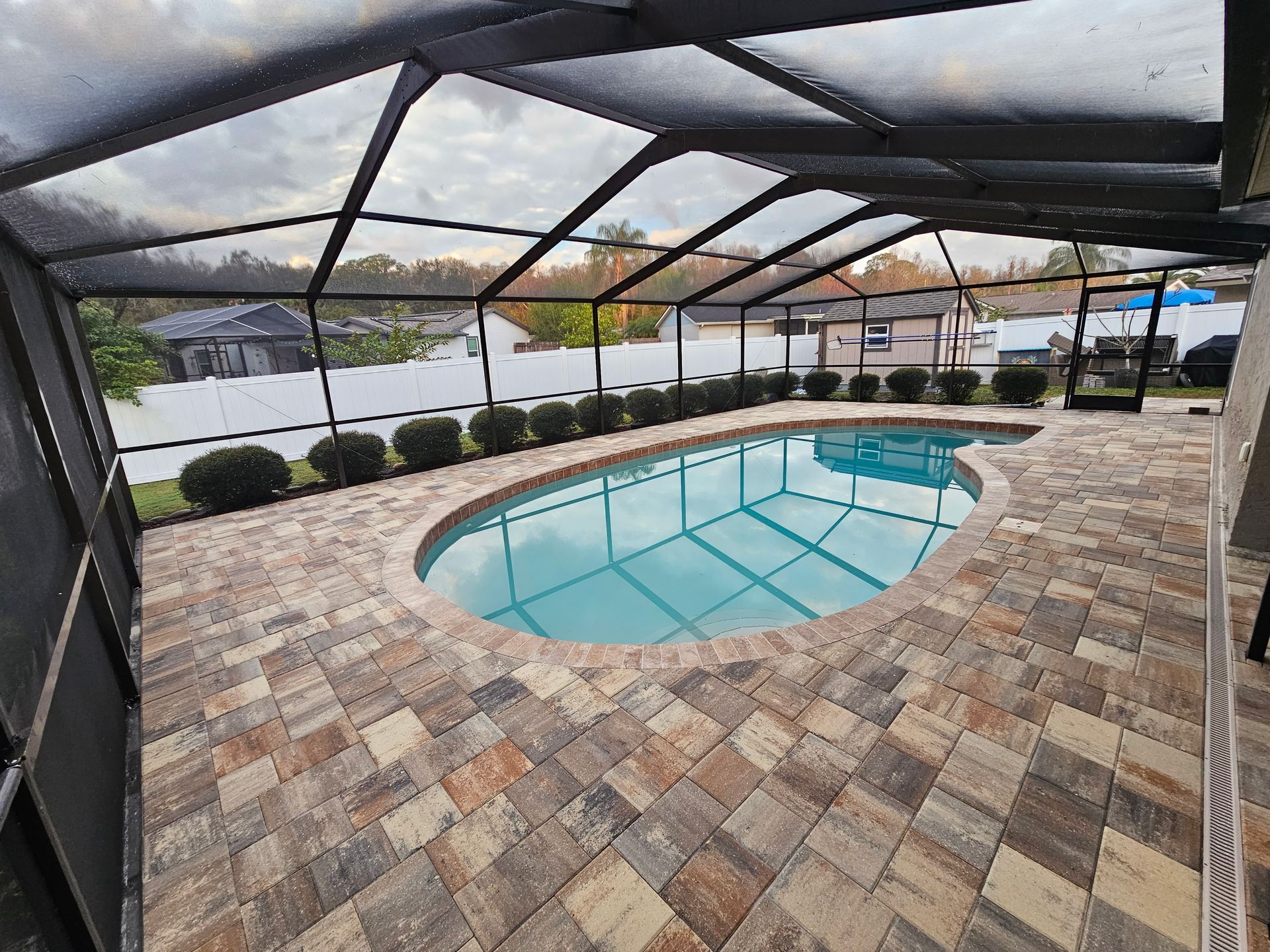 Flagstone - Victory in Cream/Beige/Charcoal with Noce travertine coping. Brick paver pool deck in Tampa, FL