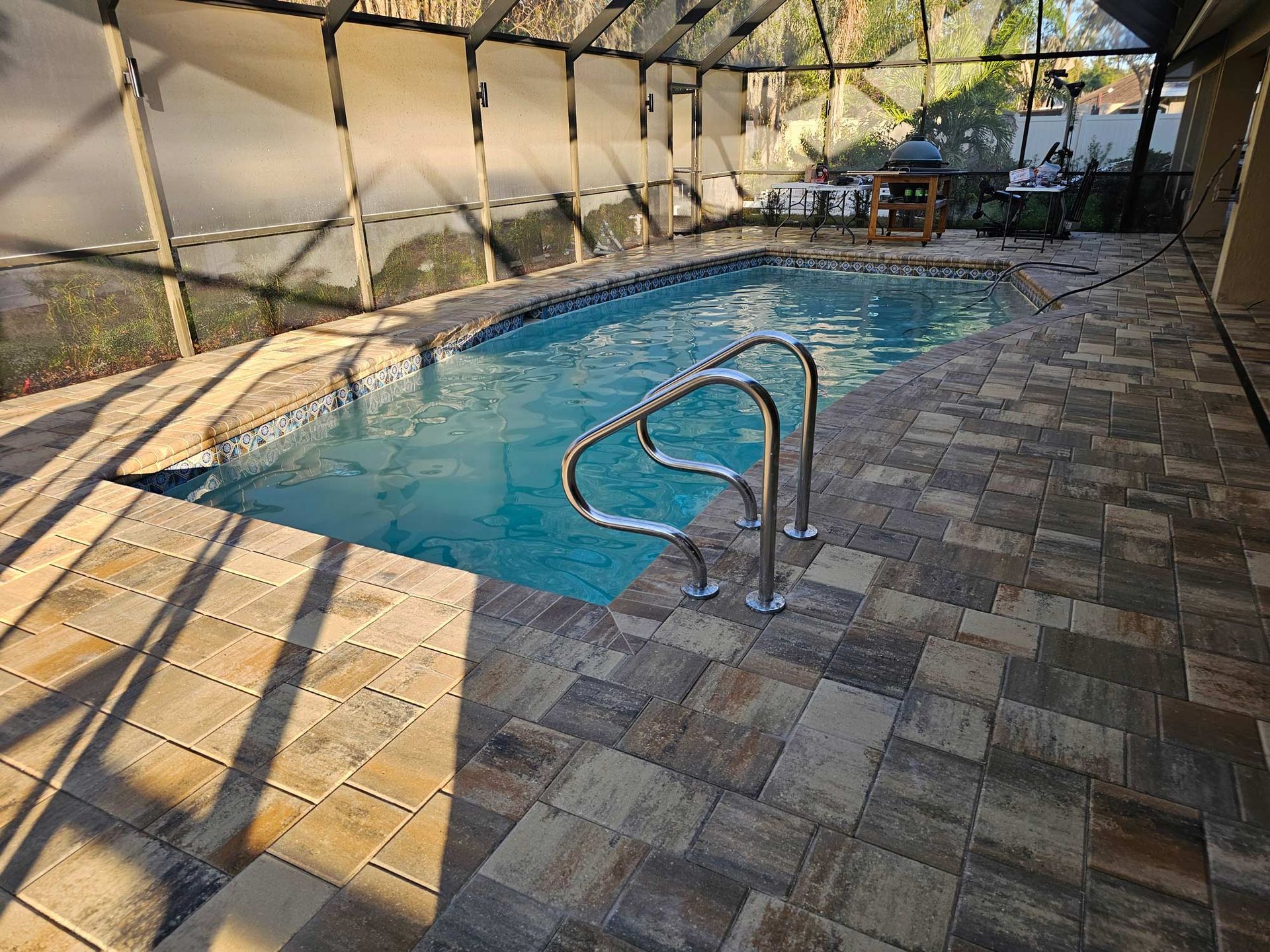 Sun Pavers screened pool deck in Tampa, FL with residential pool and paver decking.