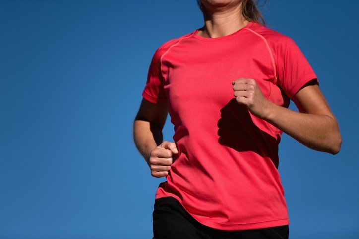 Athletic woman running in red t-shirt