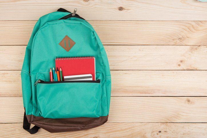Blue backpack, red notebooks and pencils