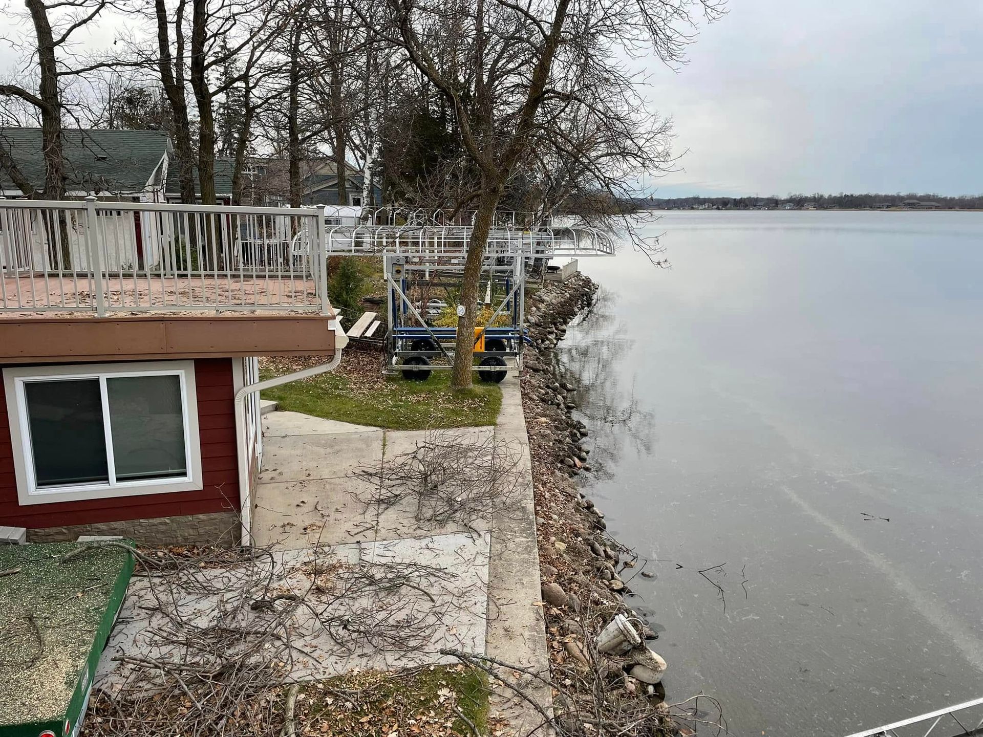 A house on the shore of a lake with a balcony overlooking the water.