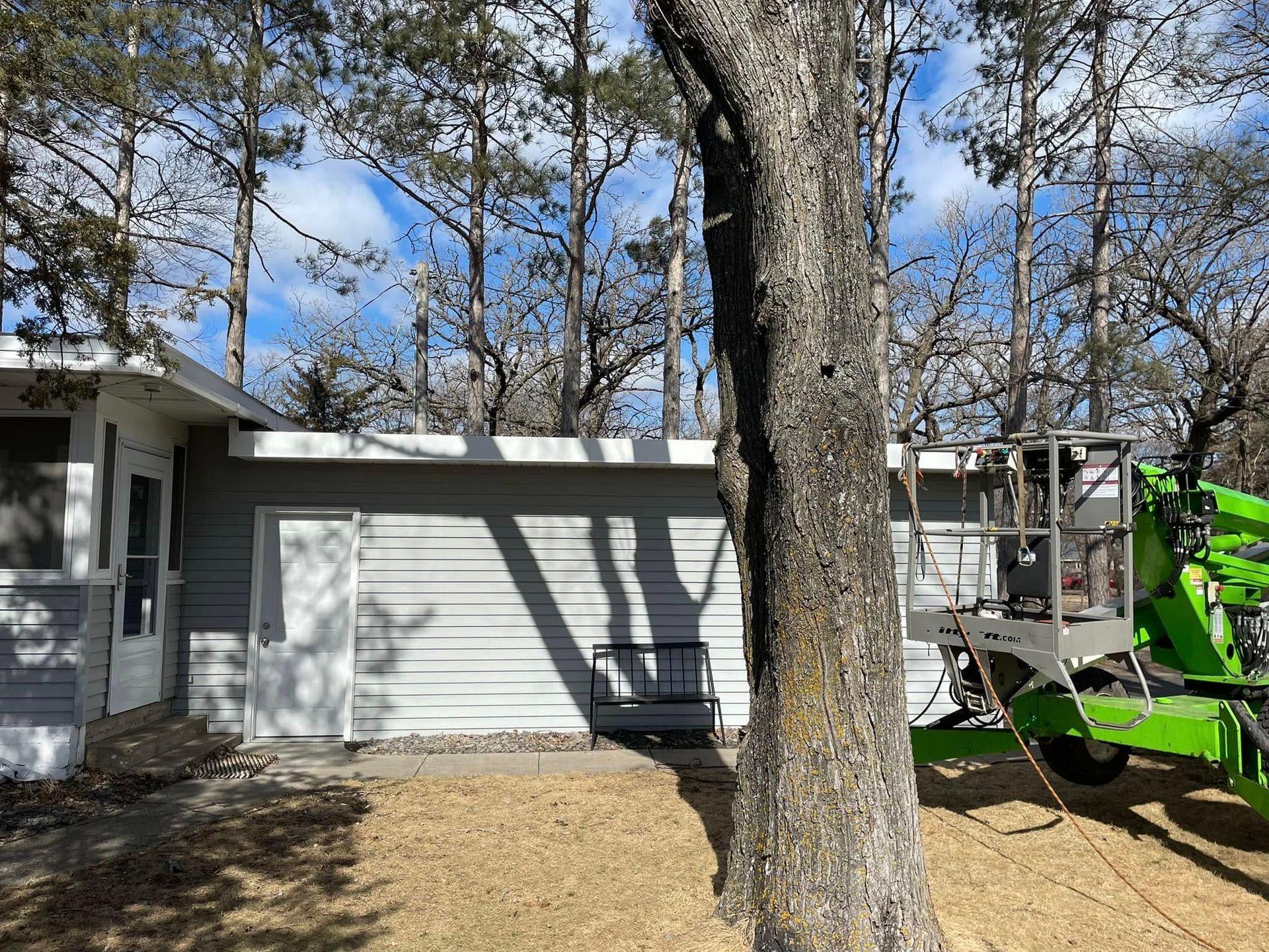 A green tractor is parked in front of a house.