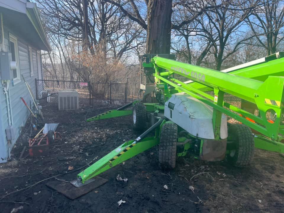 A green and white lift is parked in front of a house.