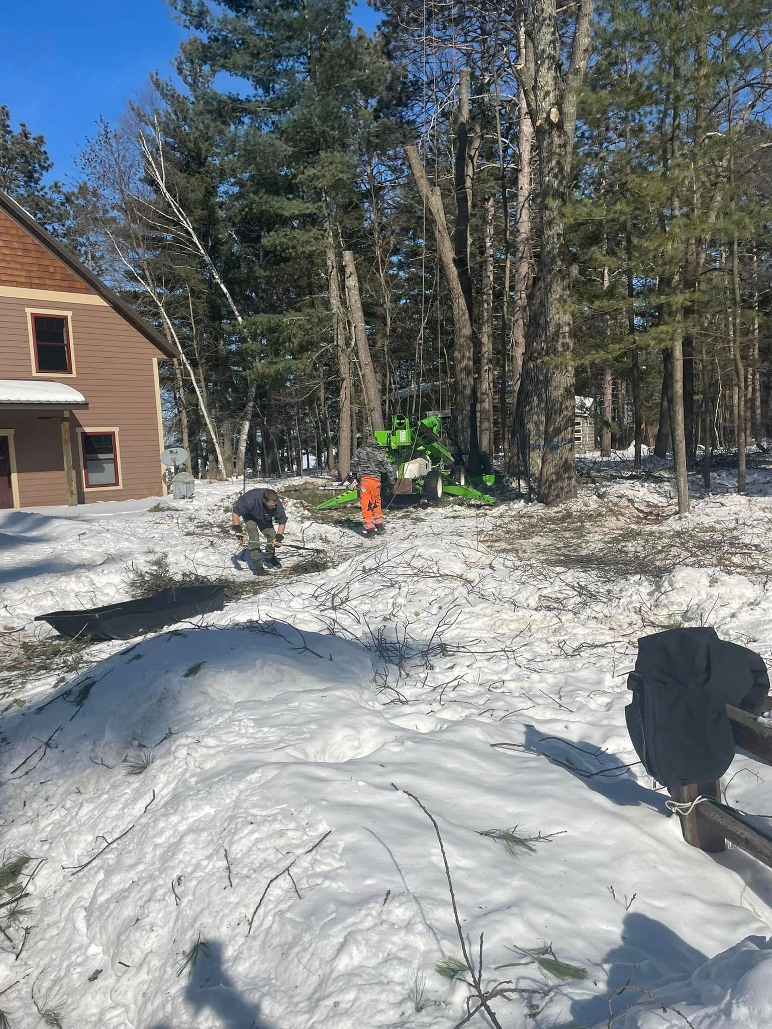 A person is standing in the snow in front of a house.