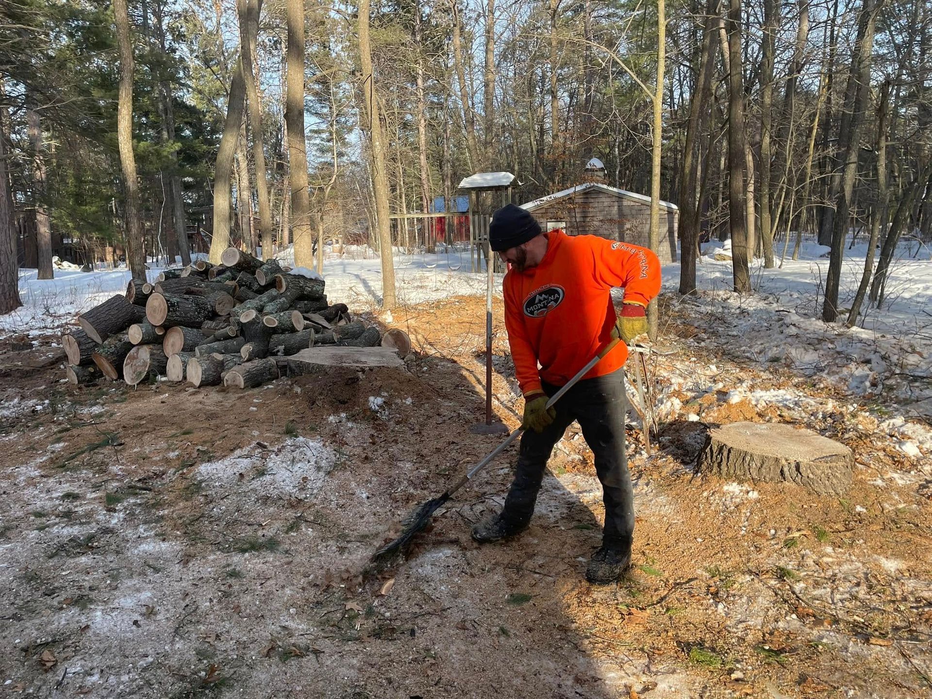 A man is standing in the snow with a shovel in his hand.