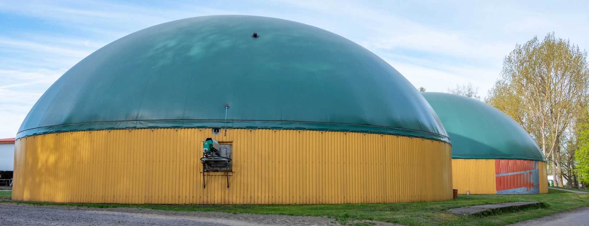 Gazebo con vista sulla piscina, tetto in tela beige, muro in pietra, piante, giornata di sole.