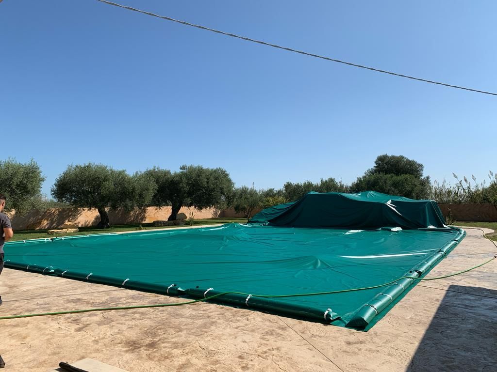 Spazio esterno ad arco con pannelli trasparenti, vista sul giardino. 