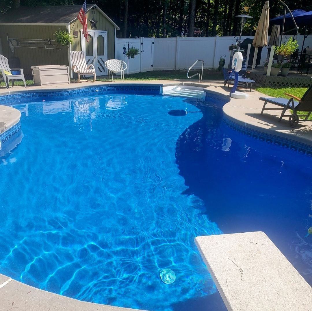 A large swimming pool surrounded by chairs and umbrellas