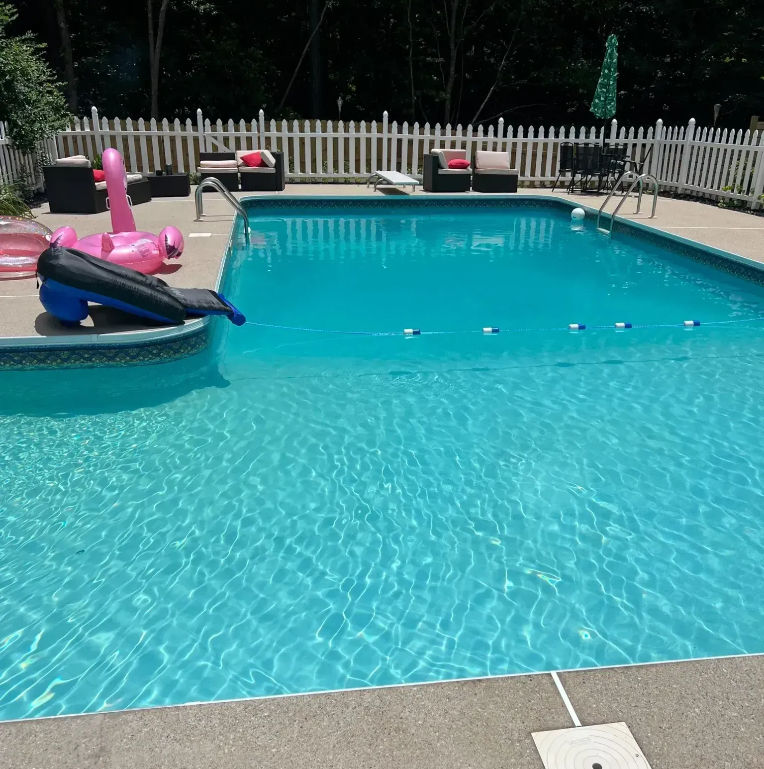 A large swimming pool with a pink flamingo float in it