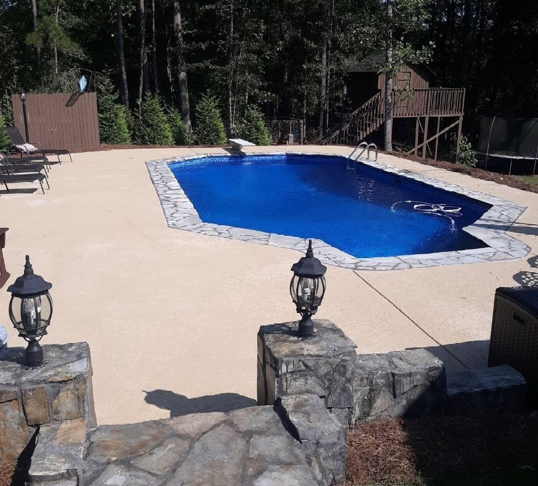 A large blue swimming pool surrounded by trees