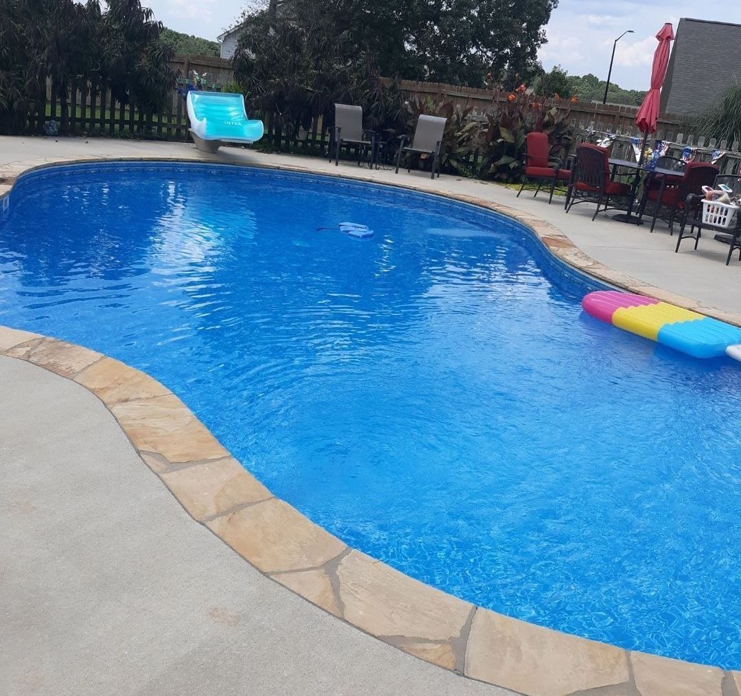A large swimming pool with a slide in the background