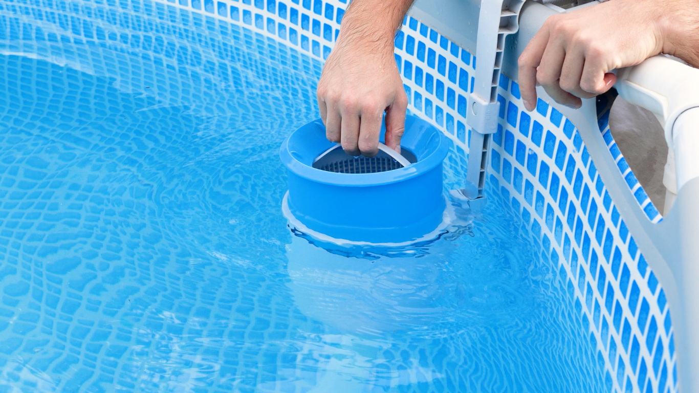 A man is cleaning a swimming pool with a skimmer.
