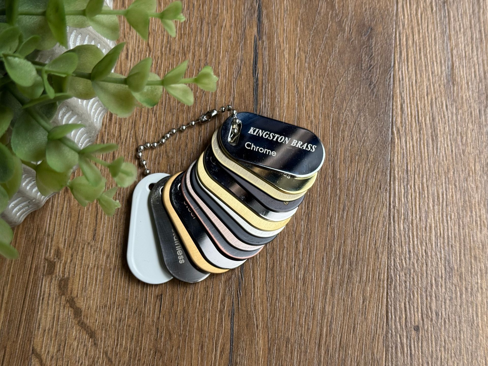 A bunch of hardware color tags are stacked on top of each other on a wooden table.