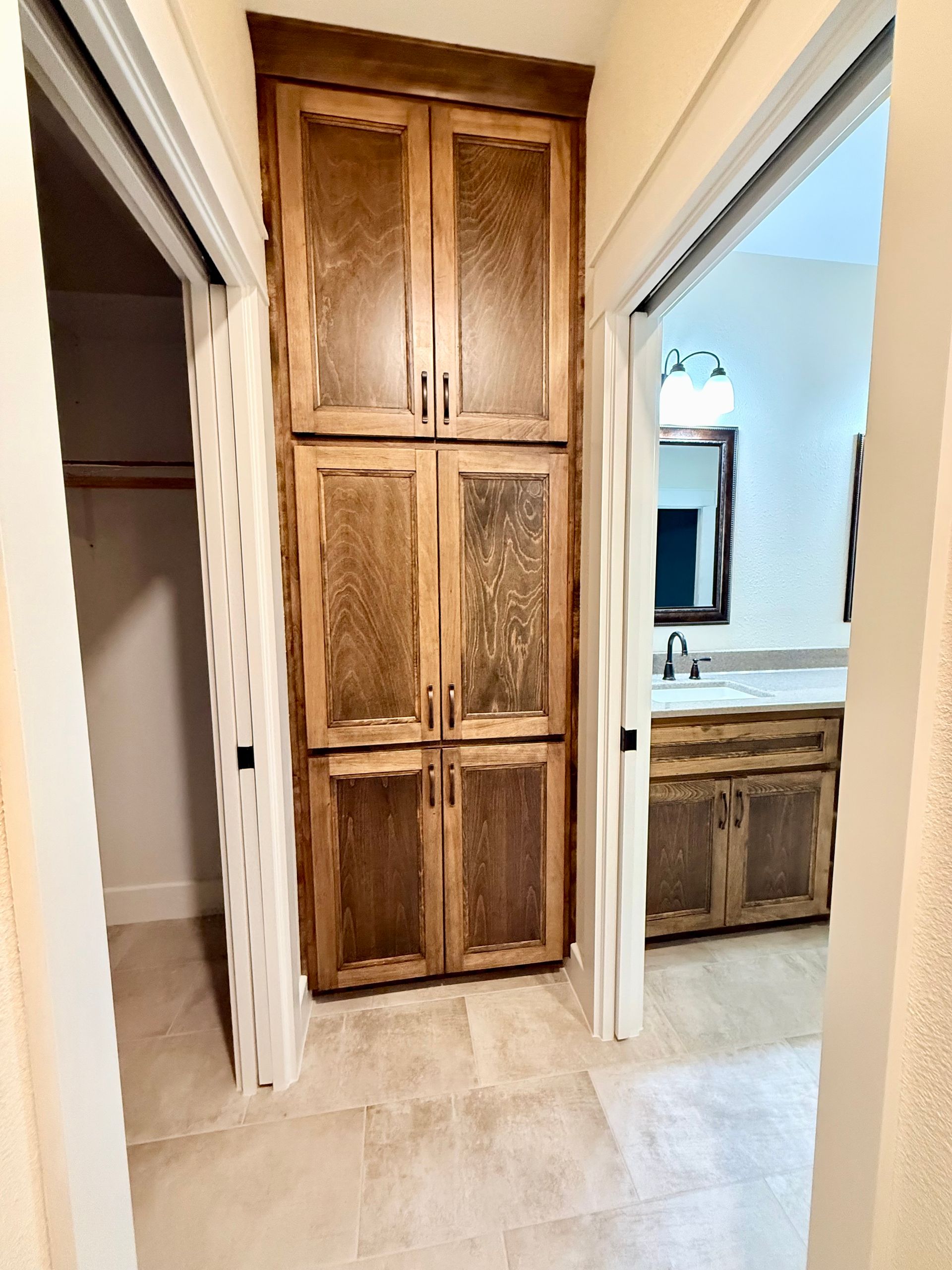 A hallway with a closet and a bathroom in the background.