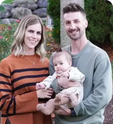 A man and a woman are holding a baby in their arms.